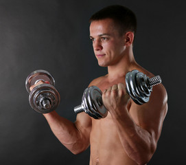 Handsome young muscular sportsman execute exercise with