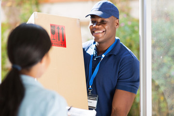 young african american delivery man delivering a package - Powered by Adobe