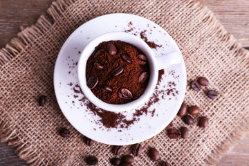 Mug of coffee beans and ground coffee