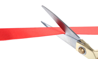 Scissors cutting red ribbon isolated on white