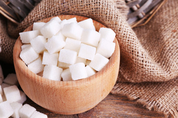 Refined sugar wooden bowl on table background
