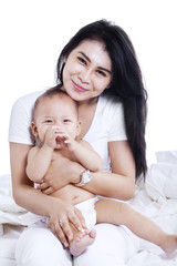 Mother and baby sitting on bed 3