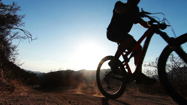 Silhouette of Man Mountain Biking At Sunset In Mountains HD