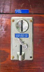 A metal coin slot panel from a coin operated machine