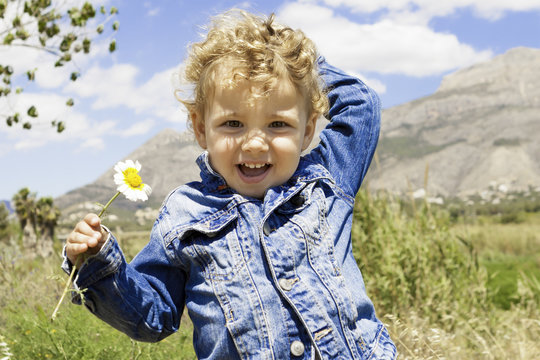 smiling child with flower in the field