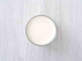 Glass of milk on white wooden floor
