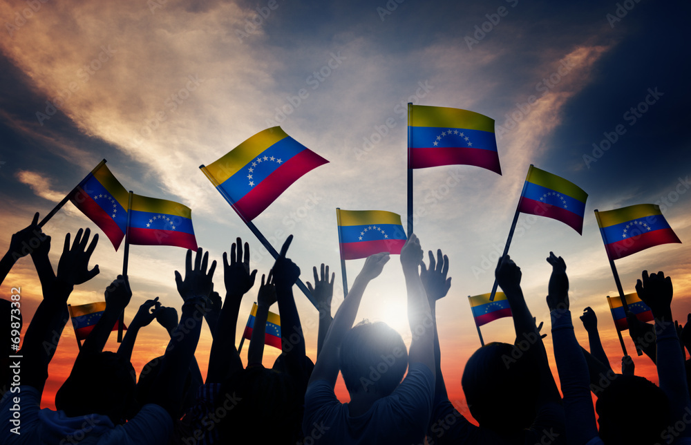 Wall mural group of people waving venezuelan flags in back lit - Wall murals