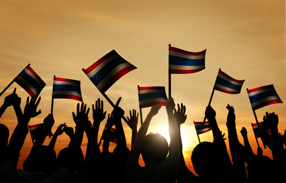 Group of People Waving Flag of Thailalnd in Back Lit