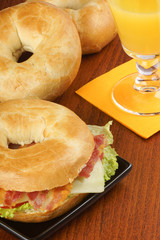 Bagel with bacon, cheese and lettuce and orange juice