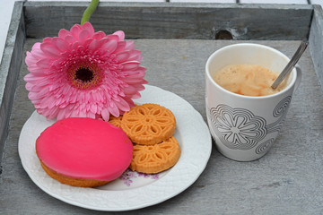 Koffie met koekjes met roze gerbera