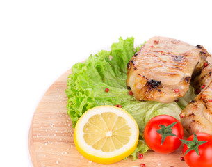 Grilled meat on wooden platter.