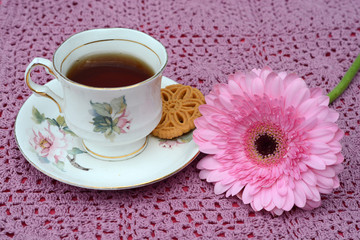 Koffie of thee in een oud kopje en een gehaakt kleedje