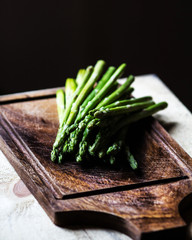 Bunch of fresh green asparagus spears tied with twine on a rusti