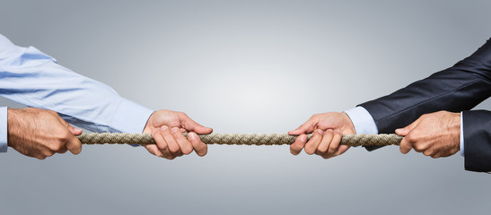 Tug war, two businessman pulling a rope in opposite directions - obrazy, fototapety, plakaty