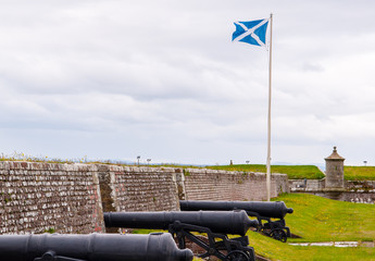 scottish flag next to cannons at fort george