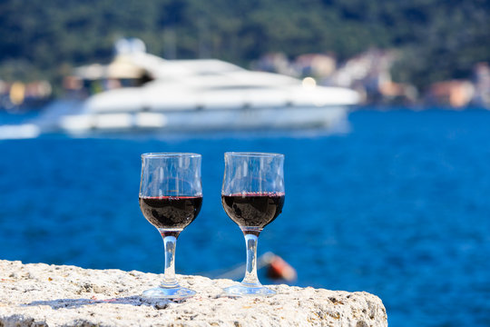 Two glasses of red wine against the sea