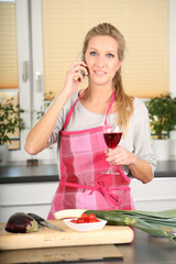 Frau in Küche mit Weinglas