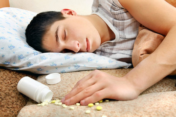 Obraz na płótnie Canvas Teenager sleeps near the Pills