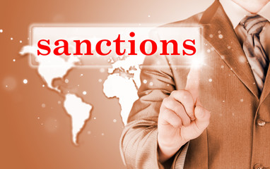 businessman pressing sanctions button on virtual screens