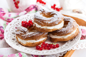Cream puff rings decorated with fresh red currant