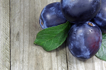 closeup of fresh plums on wooden table