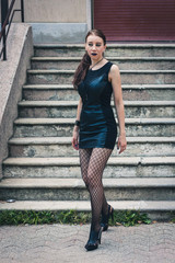 Pretty goth girl posing in urban landscape