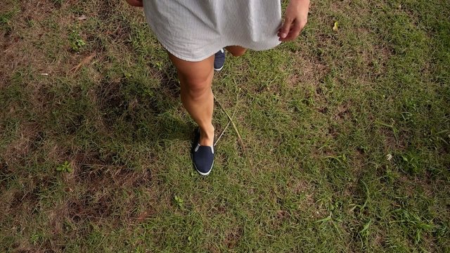 Young Female Legs Walking on the Grass. Slow Motion.