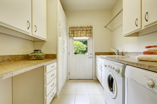 Bright laundry room with white cabinets