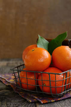 Ripe tangerine fruits in wire basket with copy space