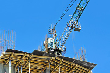 Crane and building construction site against blue sky