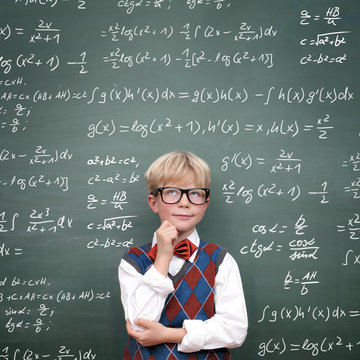 Schulkind vor der Tafel mit Formeln