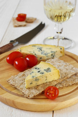 Fototapeta na wymiar Tomatoes, blue cheese on crispbread and glass of white wine