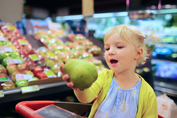 Fototapeta premium Little girl doing shopping in supermarket
