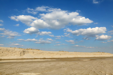 Fototapeta na wymiar Sand quarry, heap of sand and puddle, beautiful landscape