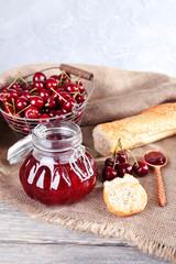 Berries jam in glass jar on table, close-up