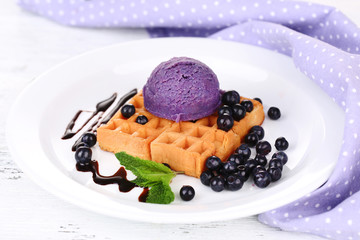 Tasty belgian waffles with ice cream on wooden table