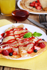 Delicious pancakes with berries on table close-up