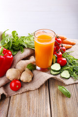 Glass of fresh carrot juice and vegetables