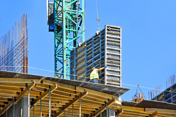 Crane and building construction site against blue sky