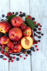 Peaches and berries in bowl on table close-up
