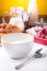 Prima colazione con donuts, brioches e tazza di  latte