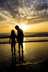 Children bathing on the beach at dusk