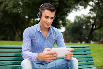 Fototapeta premium Man listening music in a city park