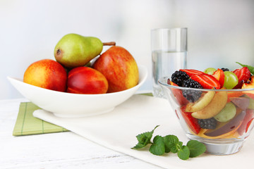 fresh tasty fruit salad on table, on light background