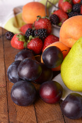 Ripe fruits and berries on tray on table close up