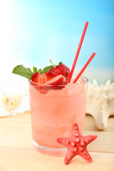 Refreshing cocktail on wooden table on blue background