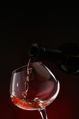 Red wine pouring into wine glass, close-up