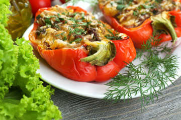 Stuffed red peppers with greens and vegetables on table close