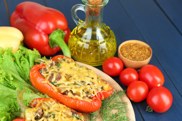 Stuffed red peppers with greens and vegetables on table close