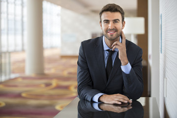 Portrait of happy businessman at office lobby